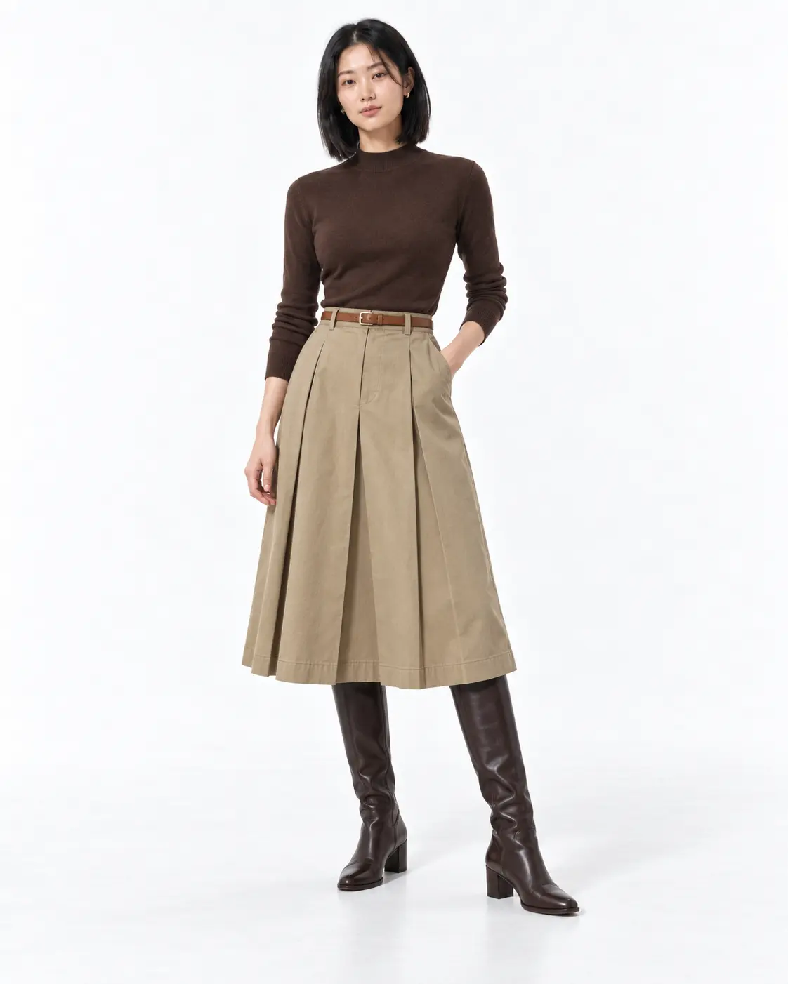 Feminine Khaki Midi Woman in a chocolate mock-neck sweater, pleated khaki midi skirt and dark-brown knee-high boots on a white background.