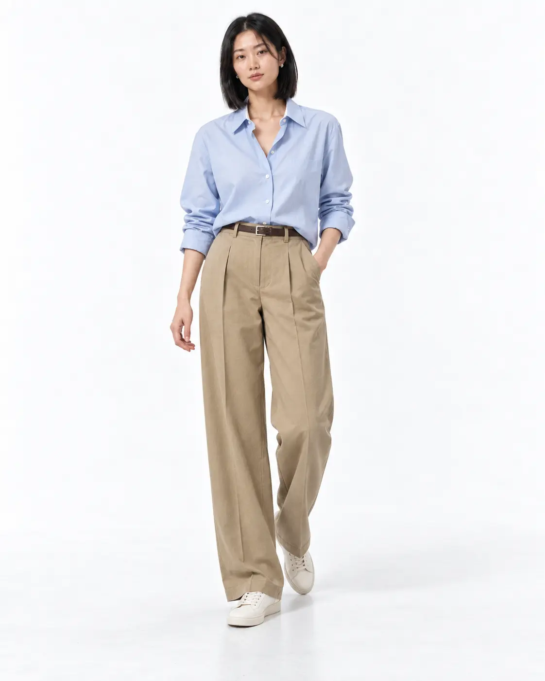Khaki Satin, Cream Denim Woman wearing an asymmetric khaki satin blouse with cream straight-leg jeans and dark-brown slingback heels in a white studio.