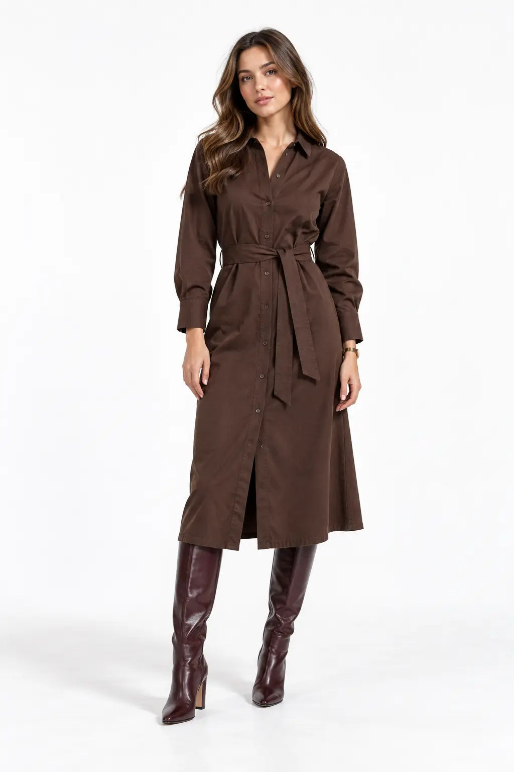 Chocolate Belted Shirt Dress Full-body white-studio image of a woman wearing chocolate twill shirt dress; self belt; oxblood knee-high boots; gold watch.