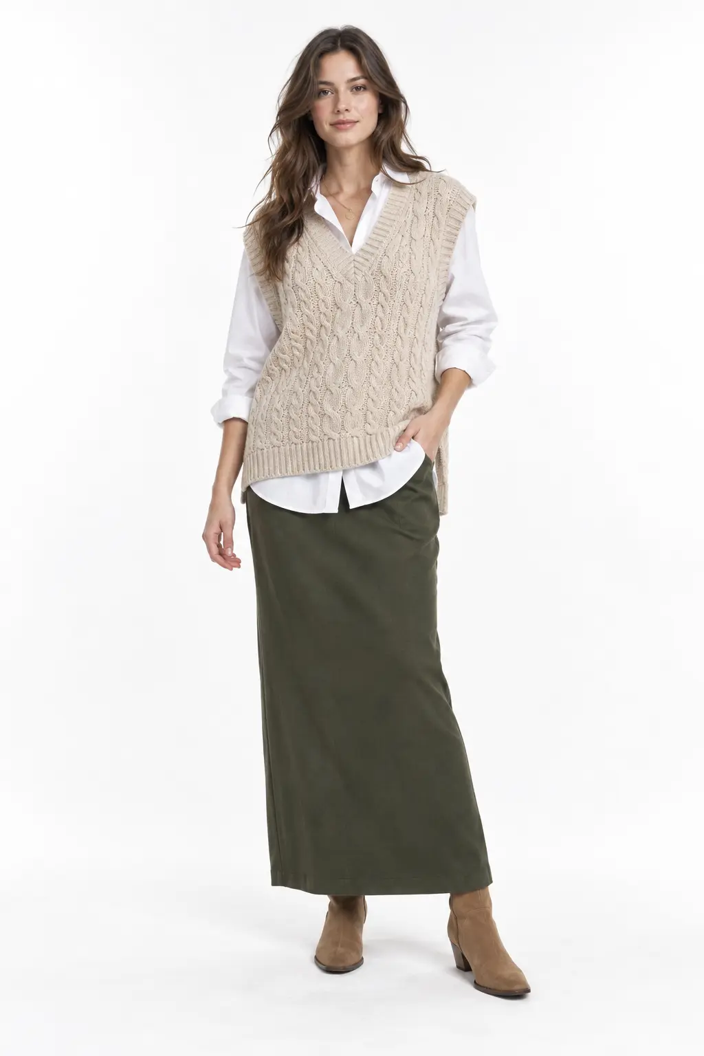 Oatmeal Vest and Olive Maxi Skirt Full-body white-studio image of a woman wearing oatmeal cable-knit vest; white poplin shirt; olive column skirt; tan suede ankle boots.