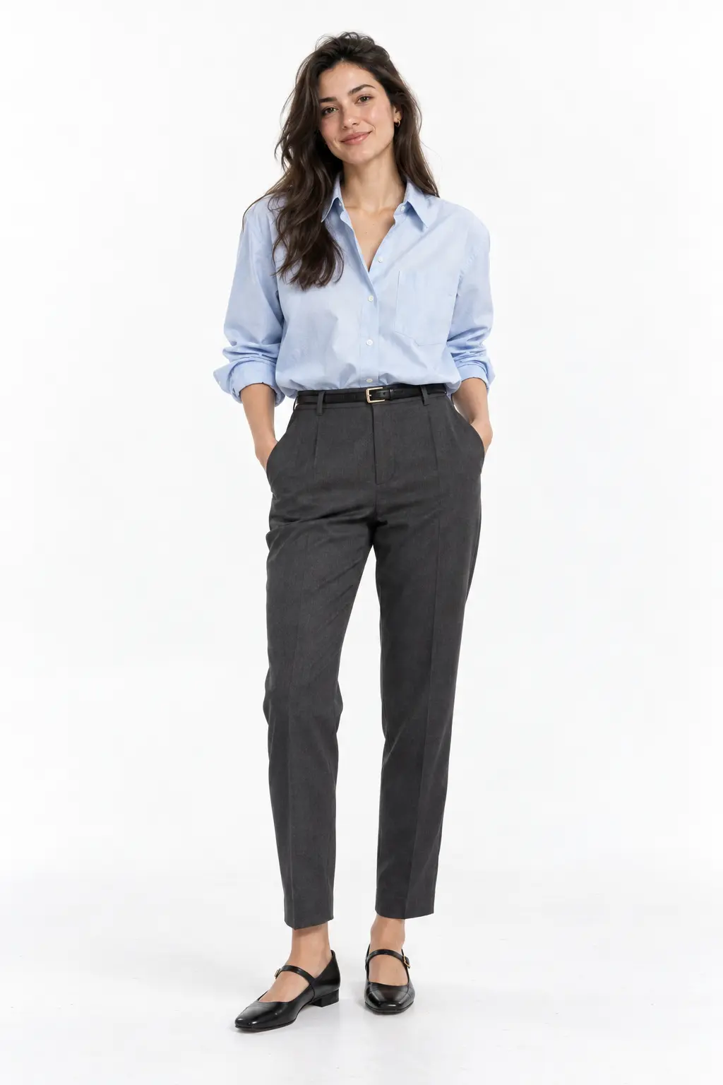 Blue Oxford and Charcoal Trousers Full-body white-studio image of a woman wearing powder-blue Oxford shirt; charcoal cigarette trousers; black Mary Janes; narrow belt.