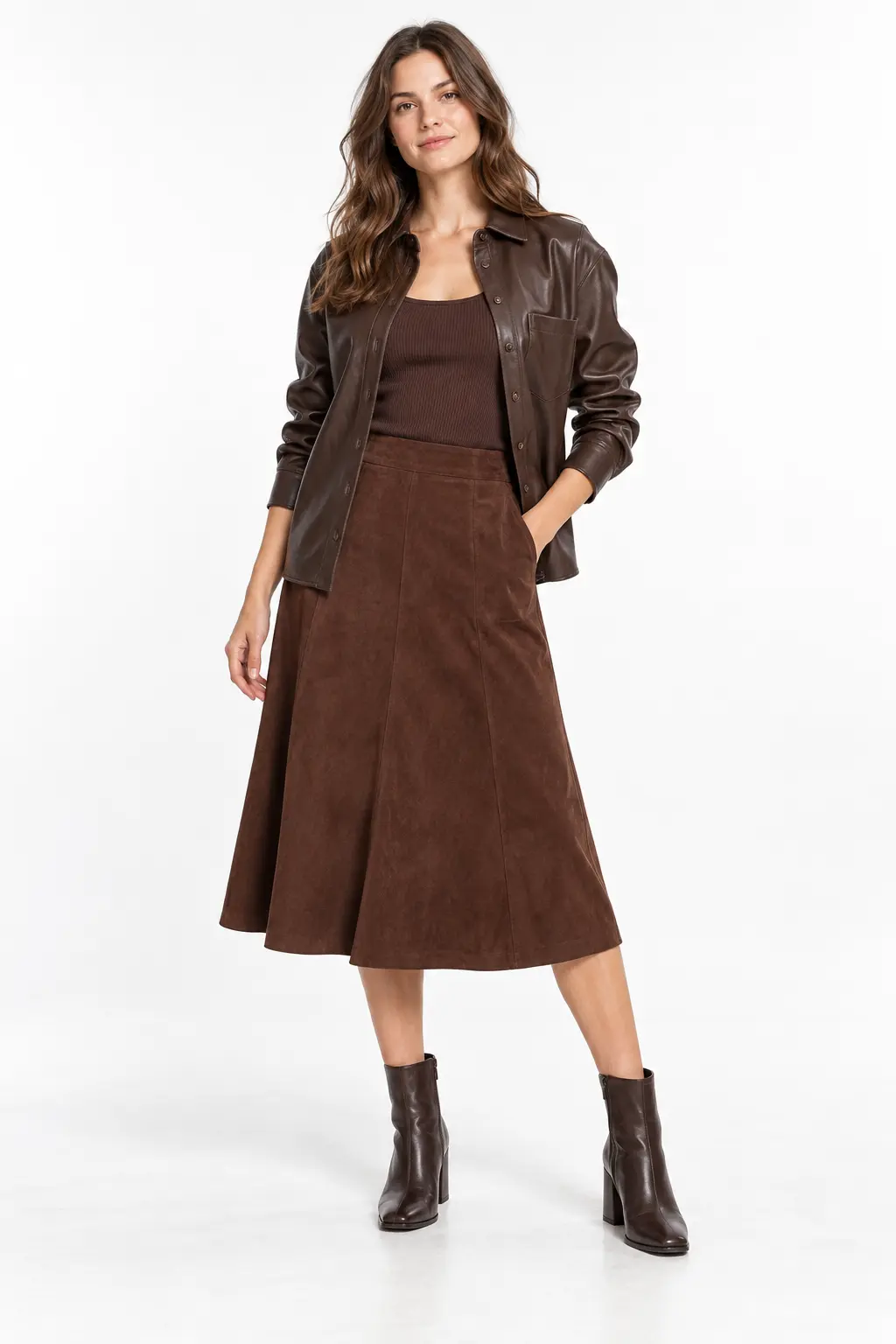 Chocolate Leather and Suede Layers Full-body white-studio image of a woman wearing chocolate shirt jacket; brown knit tank; suede A-line midi skirt; brown ankle boots.