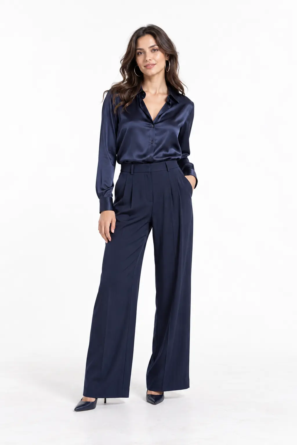 Navy Satin and Palazzo Trousers Full-body white-studio image of a woman wearing navy satin blouse; navy palazzo trousers; navy pumps; silver hoops.