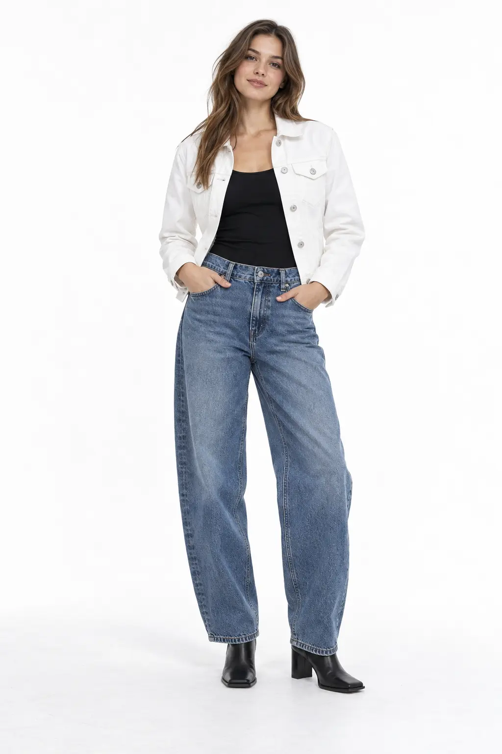 White Denim Jacket and Barrel Jeans Full-body white-studio image of a woman wearing white denim trucker; black tank; mid-blue barrel jeans; black boots.