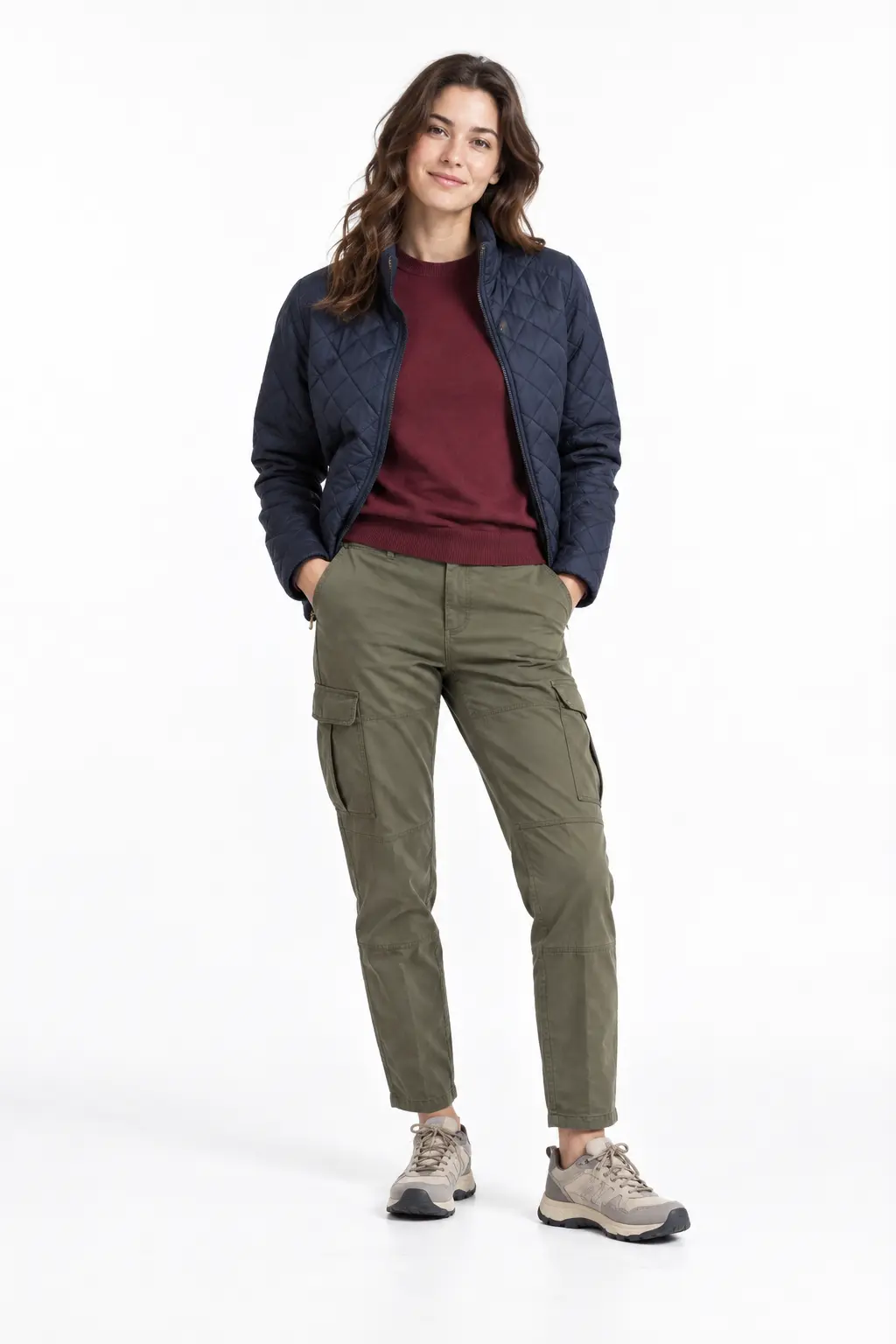 Quilted Jacket and Cargo Trousers Full-body white-studio image of a woman wearing navy quilted jacket; burgundy merino top; olive cargo trousers; neutral trail sneakers.