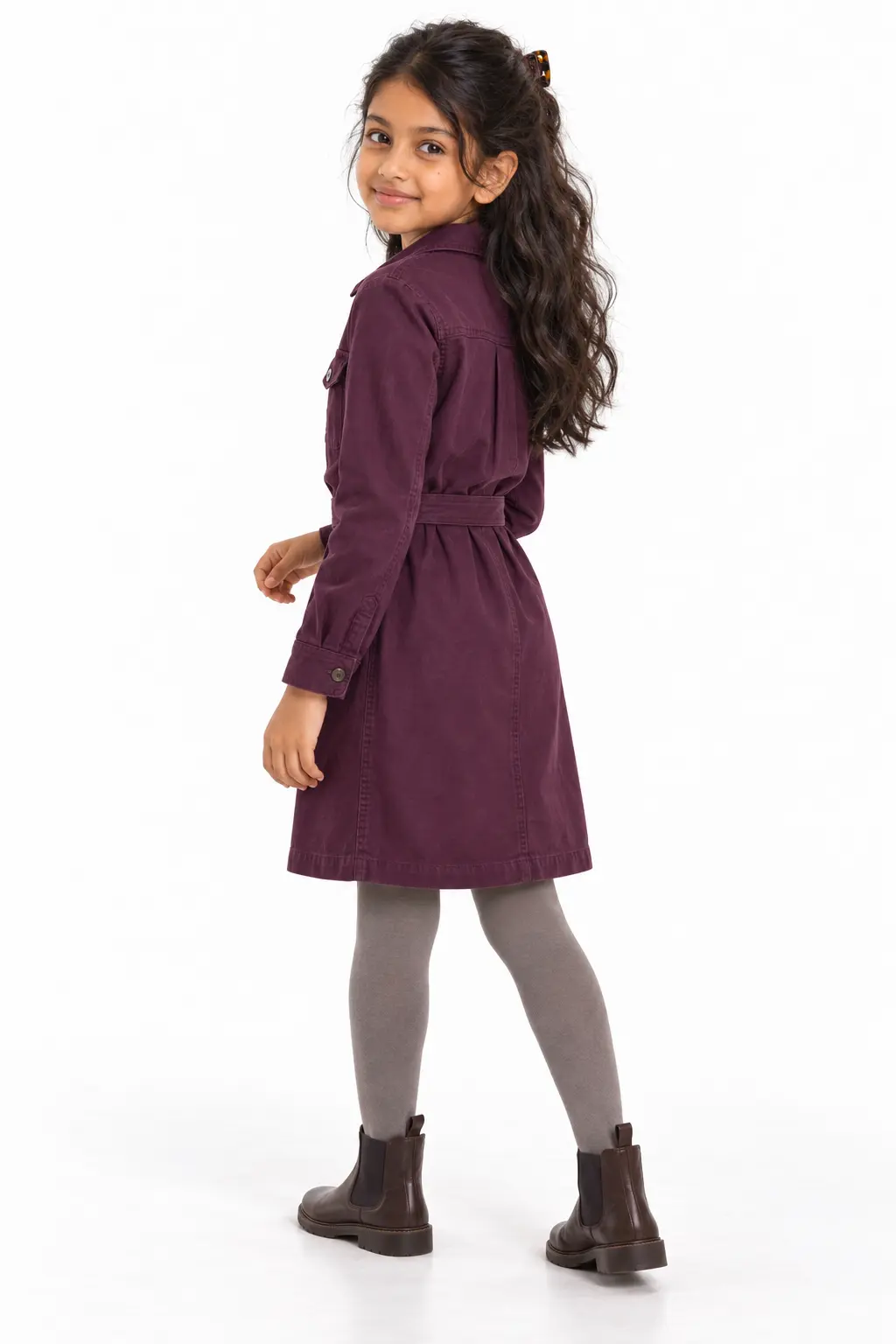 Girls' Plum Shirt Dress with Tights and Chelsea Boots Girl in a plum-colored belted shirt dress, gray tights and dark brown Chelsea boots, looking back over her shoulder.