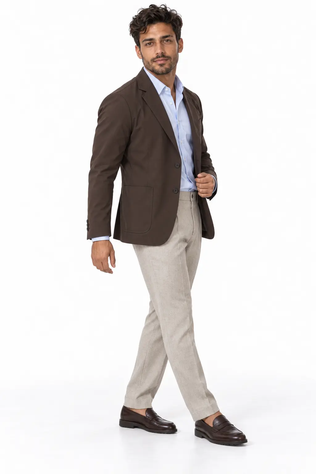 Men's Rain Blazer Office Outfit A man walking in a dark brown blazer, light blue button-down shirt, light grey trousers, and dark brown loafers.