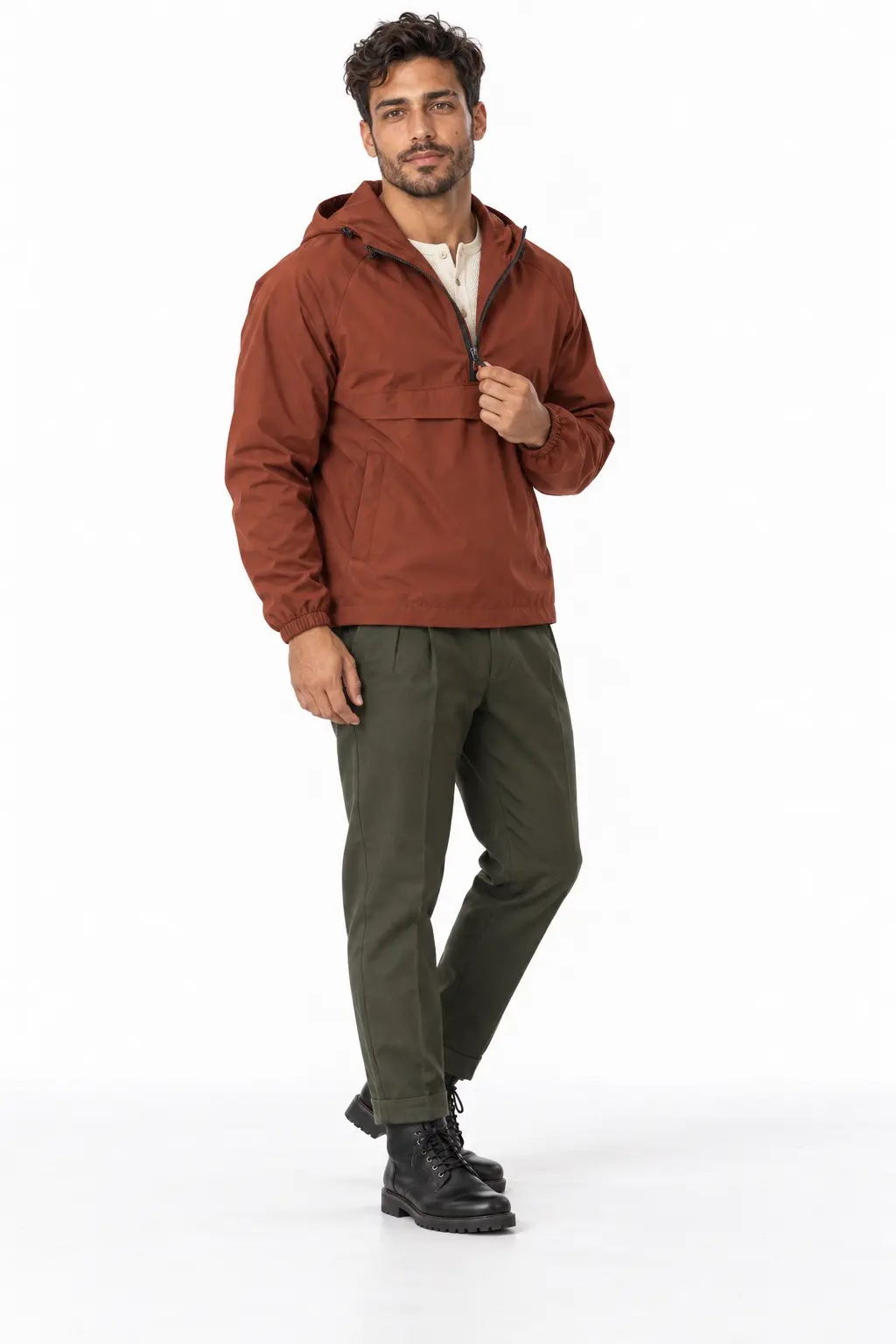 Men's Rust Anorak Rain Outfit A man adjusting the zipper on a rust-colored anorak jacket, worn with a light-colored shirt, olive green trousers, and black lace-up boots.